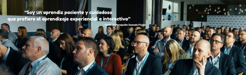 Un grupo de personas asistiendo a un seminario de negocios y la cita: 'Soy un aprendiz paciente y cuidadoso que prefiere el aprendizaje experiencial e interactivo', atribuida a una persona con el Estilo de Percepción llamado Fluido.