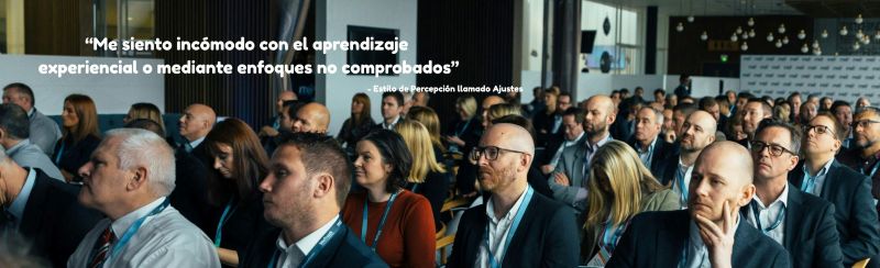 Un grupo de personas asistiendo a un seminario de negocios y la cita: 'Me siento incomodo con el aprendizaje experiencial o mediante enfoques no comprobados', atribuida a una persona con el Estilo de Percepción Ajustes.